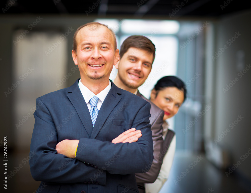 smiling employees standing around their manager smiling employees standing around their manager
