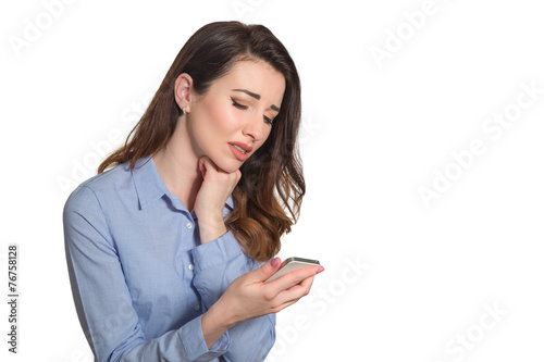 Troubled woman reading bad news on phone touching her head in mi