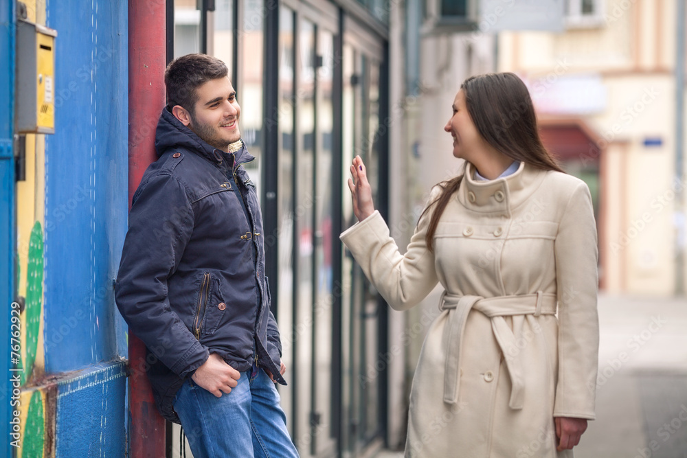 Young man and woman flirting on the street
