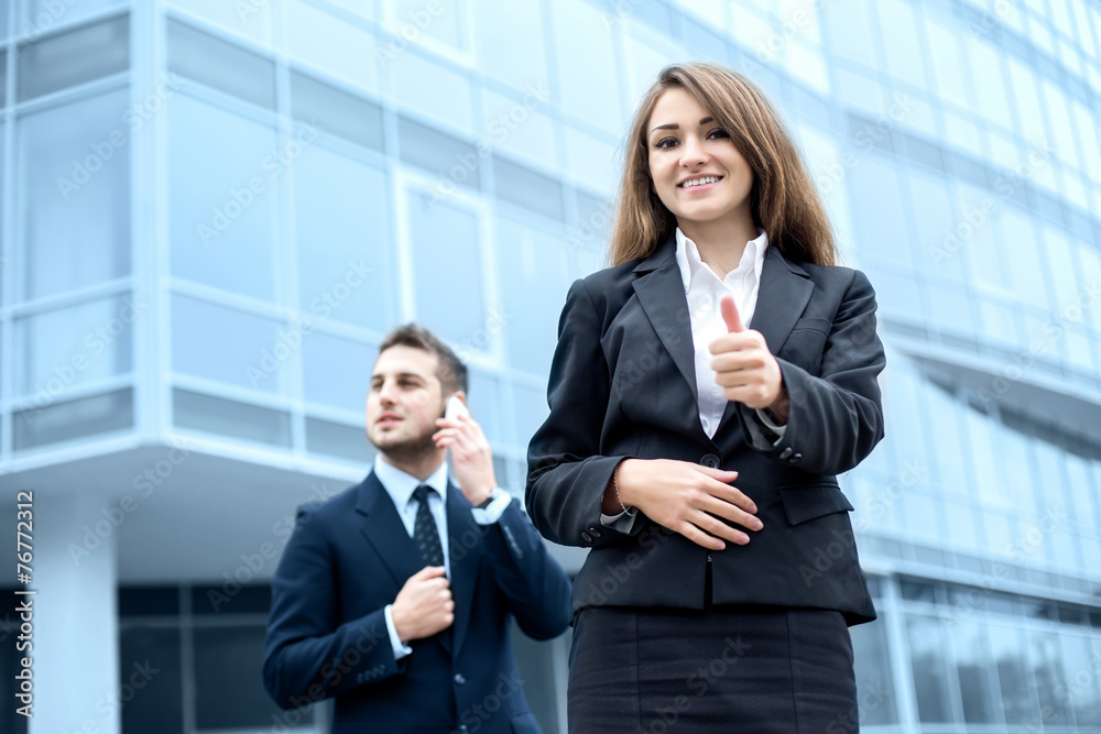 Successful young business woman showing thumbs up sign Successful young business woman showing thumbs up sign