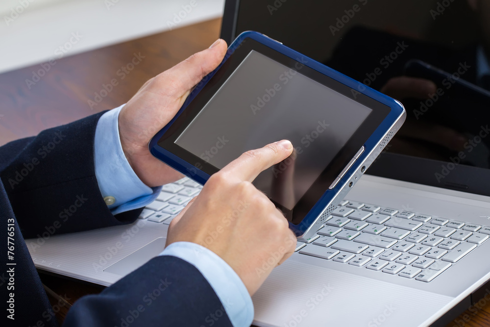 Businessman working on laptop and tablet Businessman working on laptop and tablet