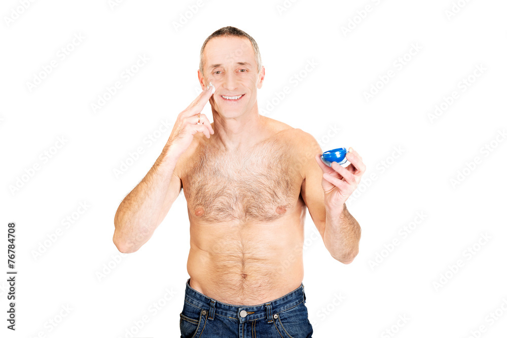 Fototapeta premium Portrait of a man applying cream on his face