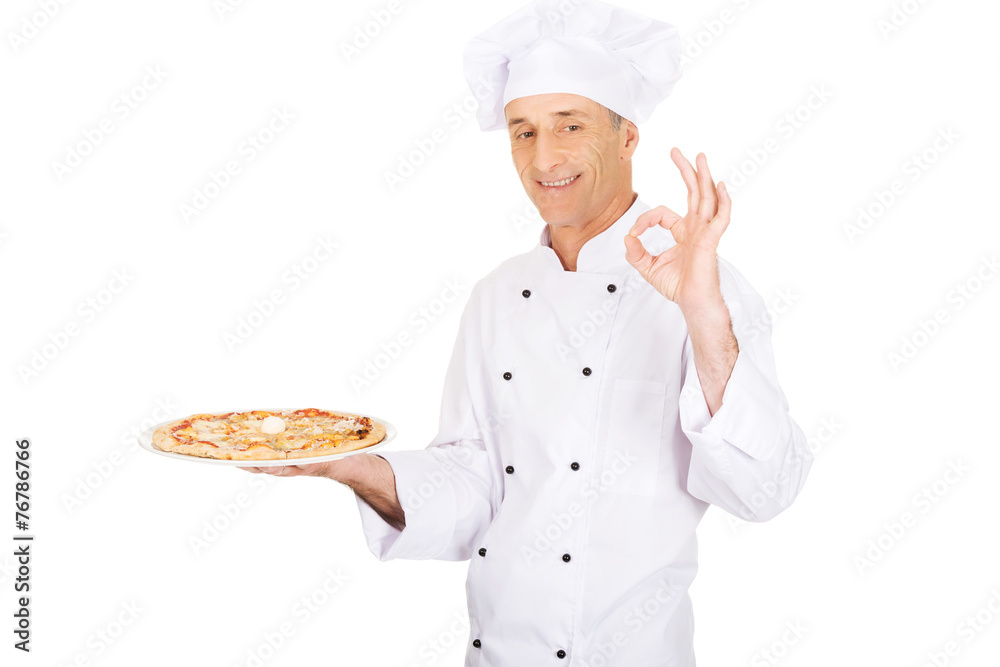Chef baker with italian pizza showing perfect sign