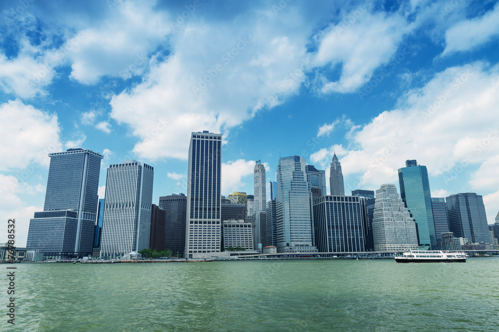 Lower Manhattan skyline with boat crossing river