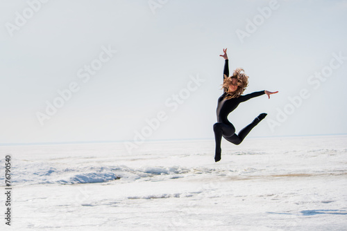 beautiful girl jumping jumping in the snow