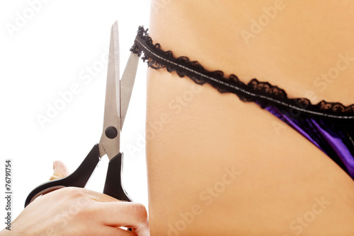 Men hand cutting off women lingerie.