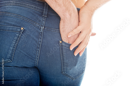 Male hand in woman's jeans pocket.