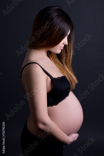 young beautiful pregnant woman in lingerie over grey