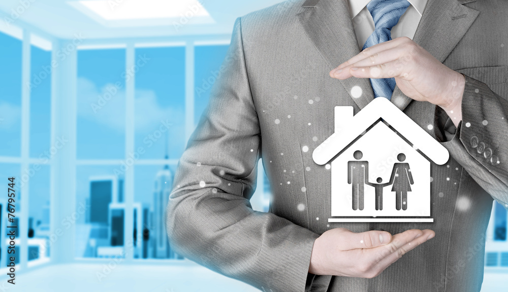 businessman protecting family in home with hands businessman protecting family in home with hands