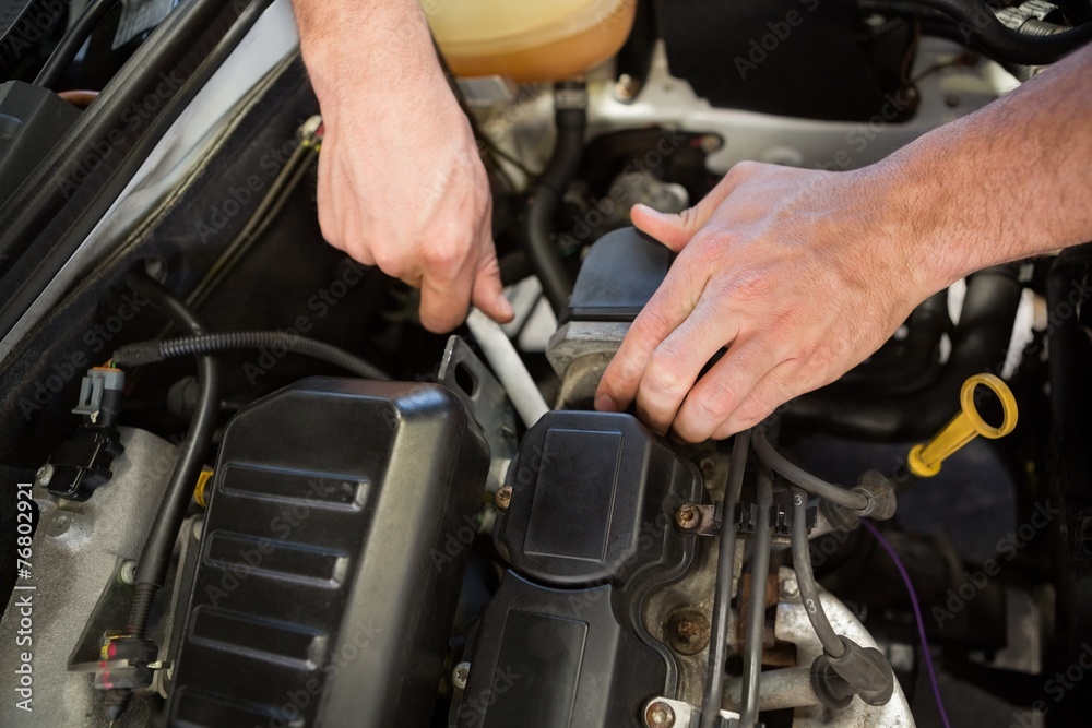 Mechanic working under the hood Mechanic working under the hood