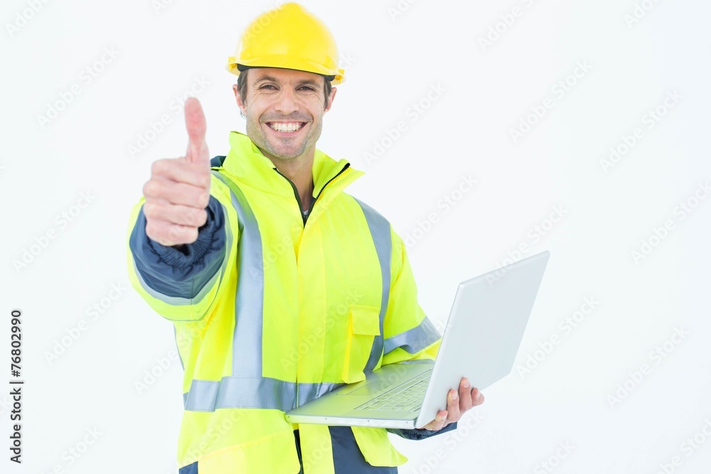 Architect in reflective clothing with laptop gesturing thumbs up Architect in reflective clothing with laptop gesturing thumbs up