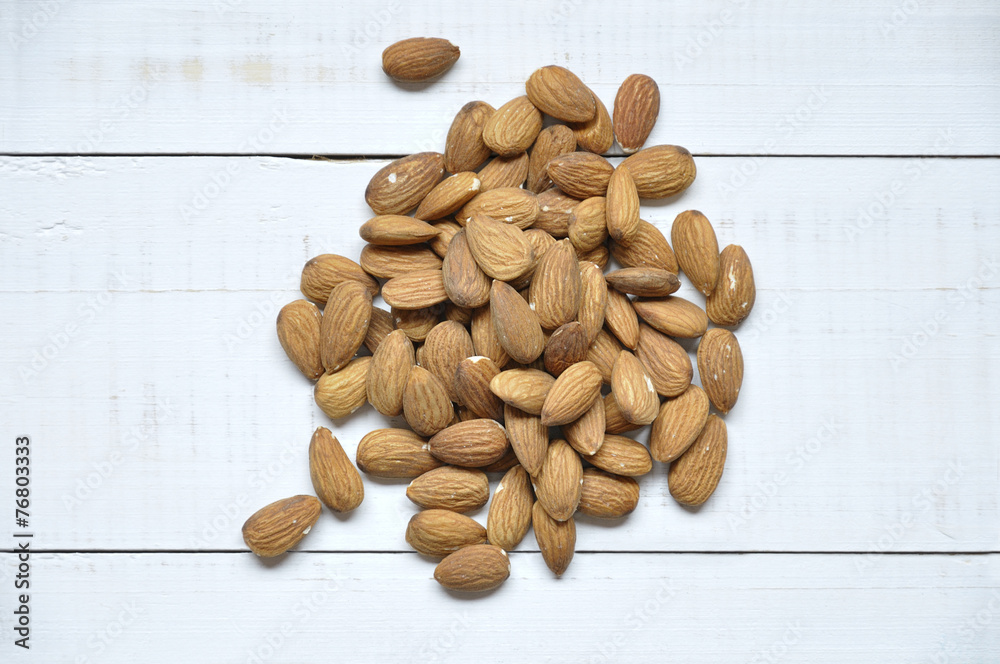 Group of almonds on a white wooden table