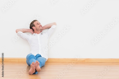 Casual man sitting on floor at home