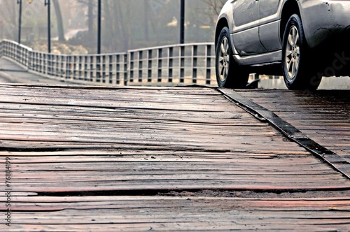 car passes on an old wooden bridge