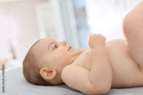 Baby boy laying on changing table in bedroom