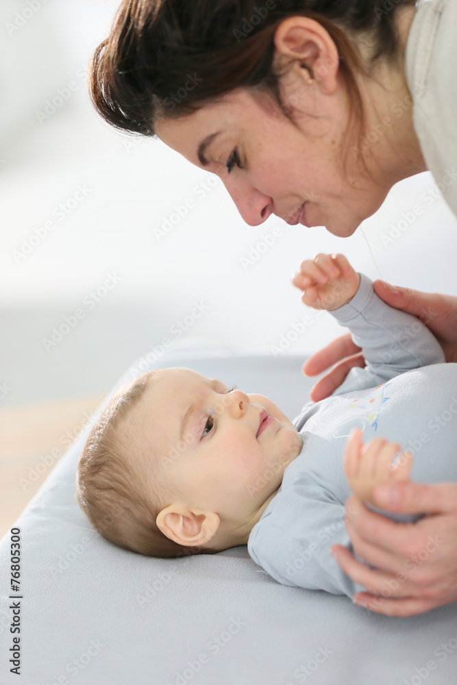 Mommy cuddling baby boy on changing table Mommy cuddling baby boy on changing table