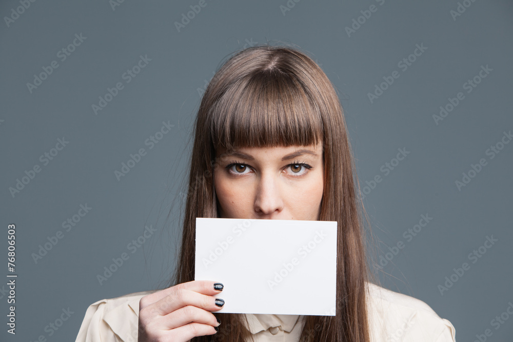 Naklejka premium Pretty young girl holding white empty card
