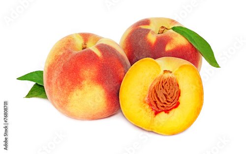 Two whole and a half peaches with green leaves (isolated)
