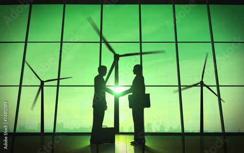 Green business shake hand silhouette with windmill.