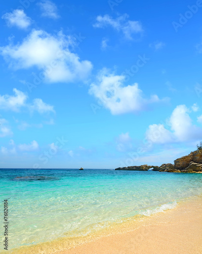 Cala Biriola under a blue sky with clouds