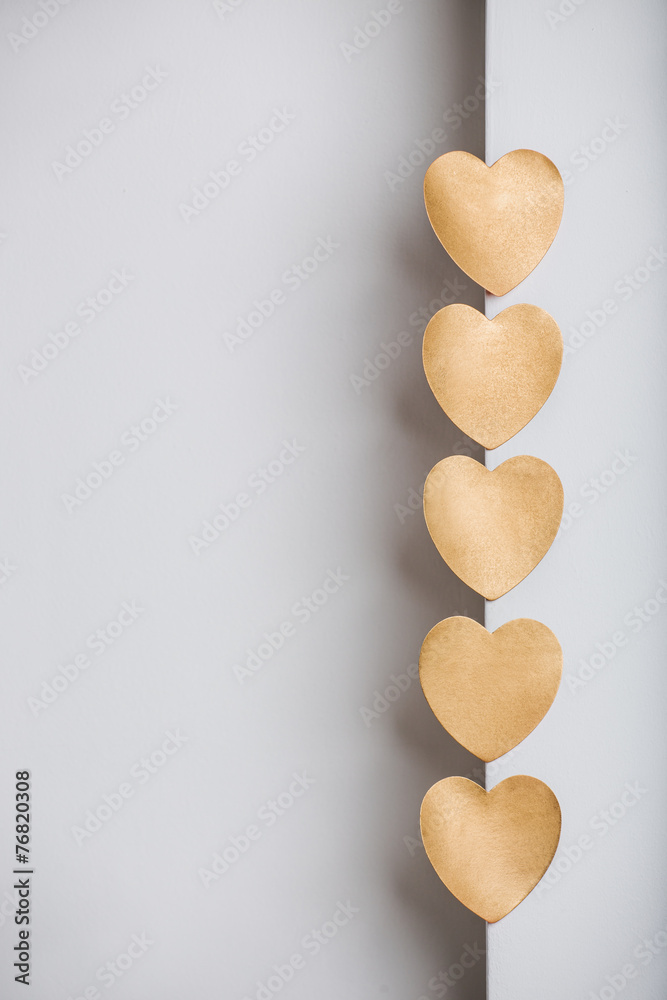 Gold heart stickers on grey textured background with blank space