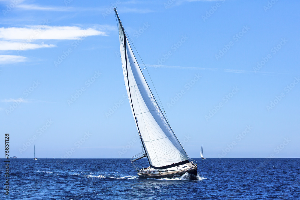 Sailing ship yachts with white sails in the open Sea.