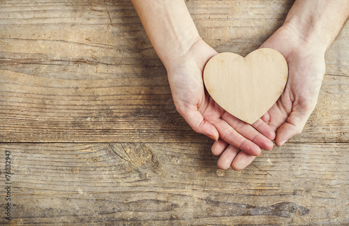 фотографія Hands of man and woman holding a heart together.