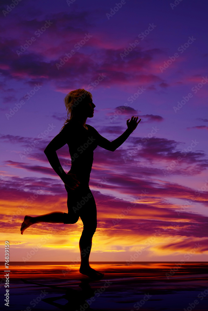 silhouette of a woman running in the sunset water