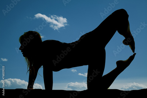 silhouette of woman on one hand and knee toes together