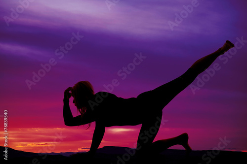 silhouette of woman on one hand and knee leg up hand on head
