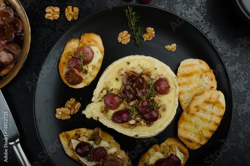 Brie cheese baked with nuts and grapes