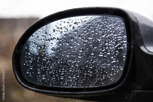 Drops of water on a car mirror.