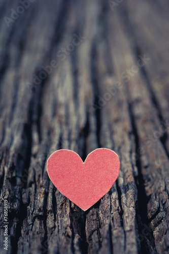 Red Valentine heart on old rustic wooden background.
