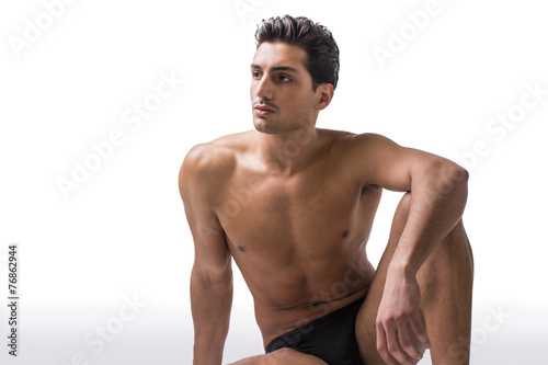 Handsome latin young man sitting naked on floor