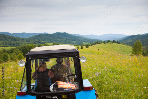 Man and woman farmers ride on the tractor in Russia