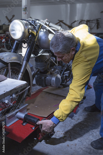 man adjusting a motorbike.