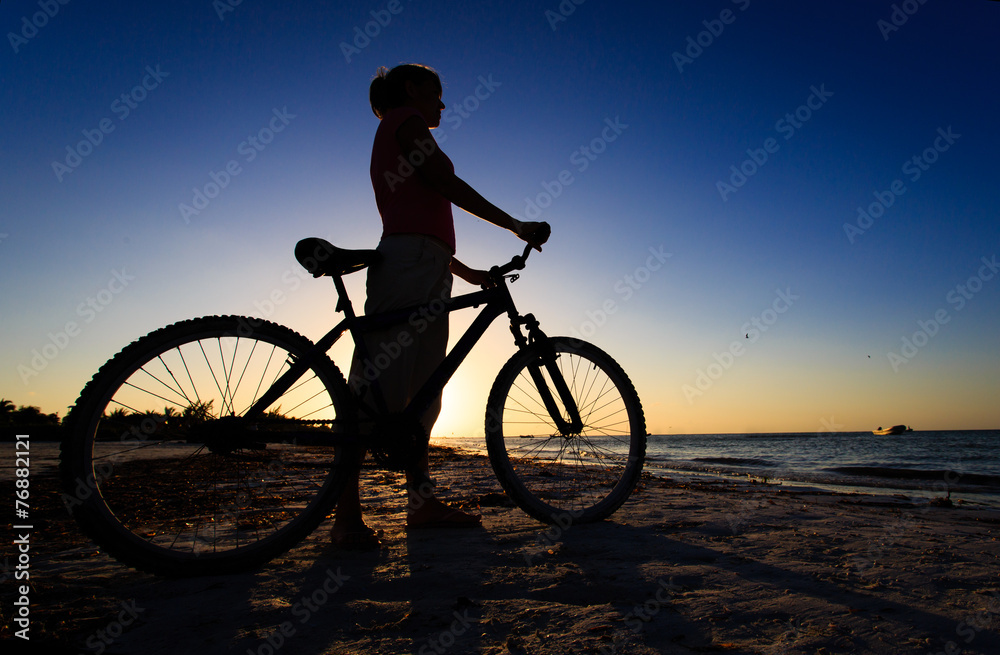 Fototapeta premium woman biking at sunset