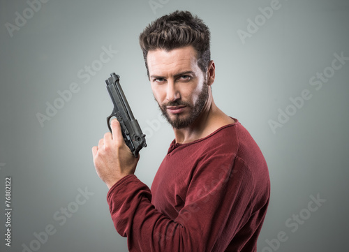 Foto Cool young man holding a gun