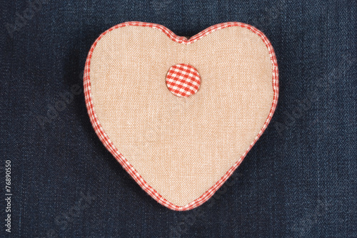 Fabric handmade heart on a blue denim jeans background