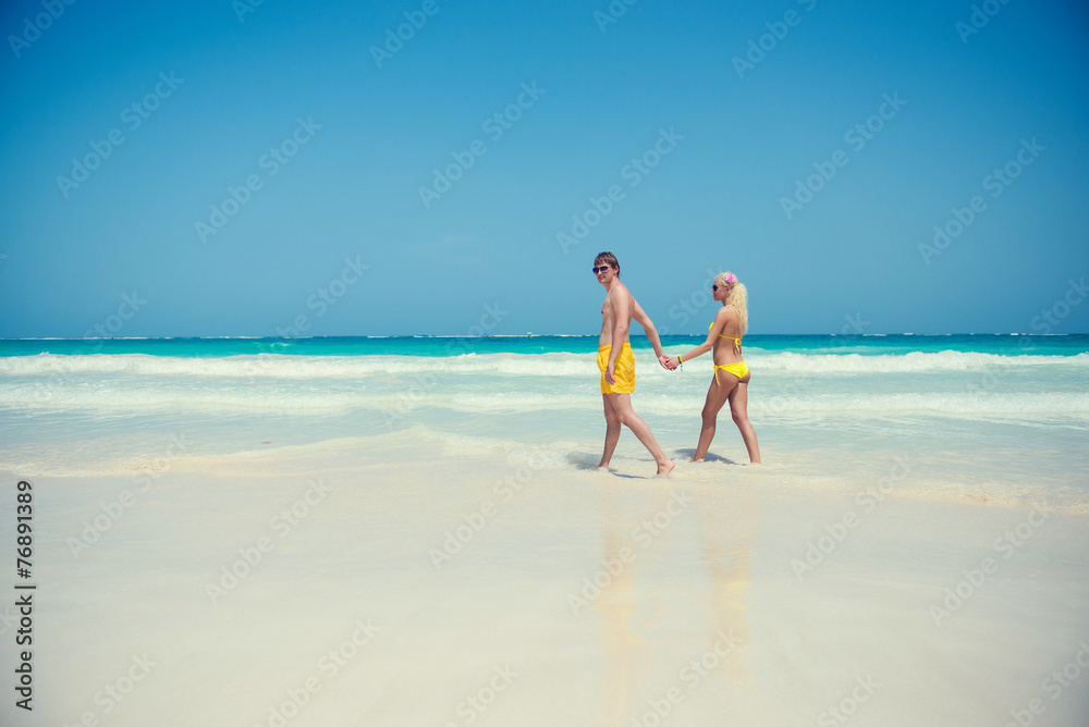 Young couple walking along the seashore Young couple walking along the seashore