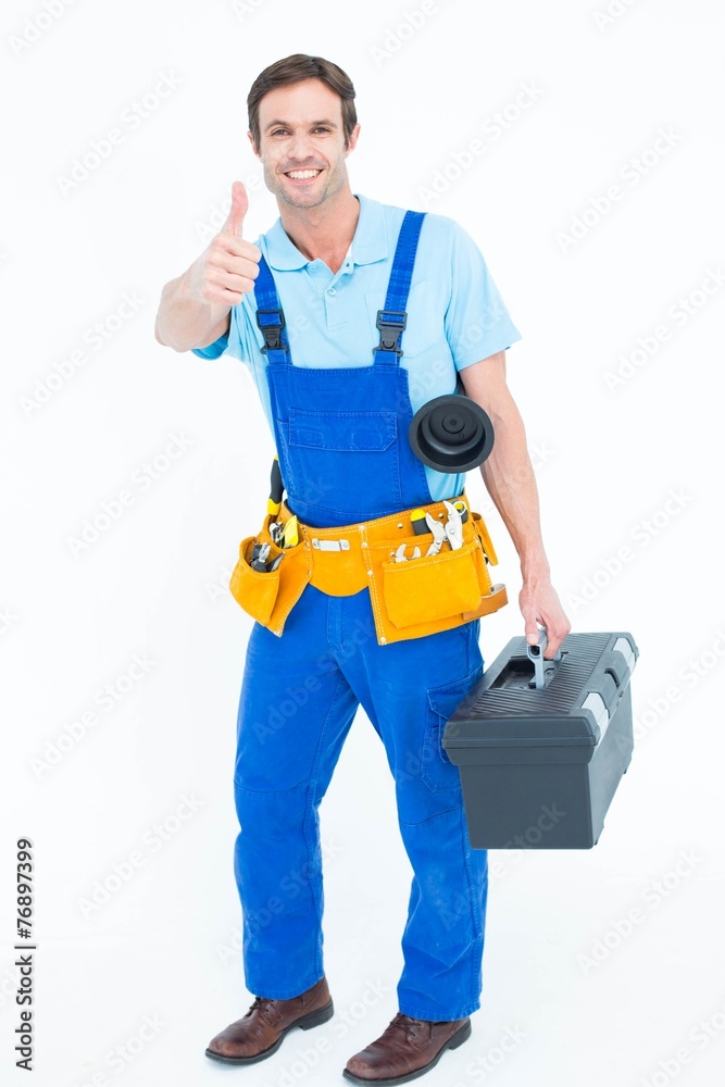 Plumber carrying tool box while gesturing thumbs up Plumber carrying tool box while gesturing thumbs up