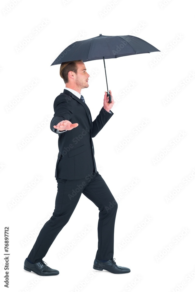 Concentrated businessman with umbrella walking Concentrated businessman with umbrella walking