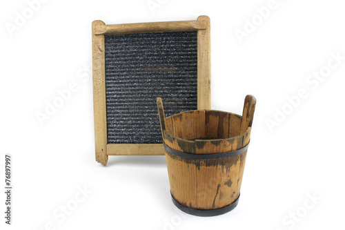 Old washboard and wooden bucket on white background