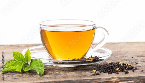 Glass Cup Tea with camomile flower and Mint Leaf, on brown woode