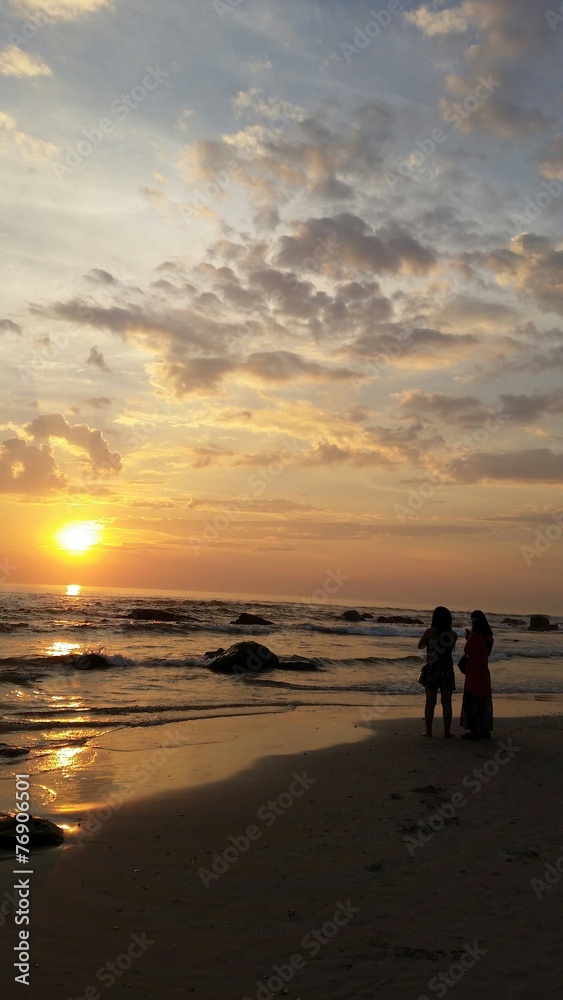 Two women watch the sunrise at huahin beach Thailand