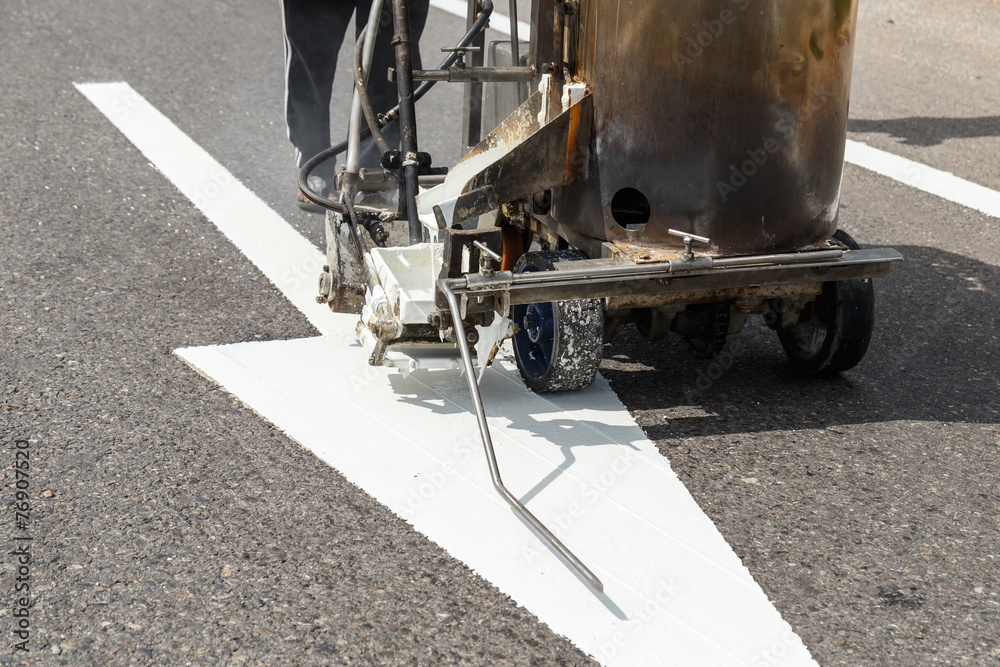 Worker and painting machine work on the street in Thailand