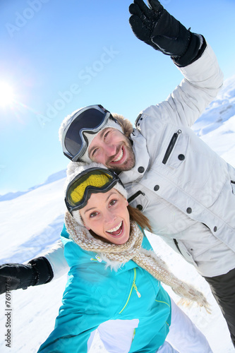 Cheerful couple having fun at top of ski slope