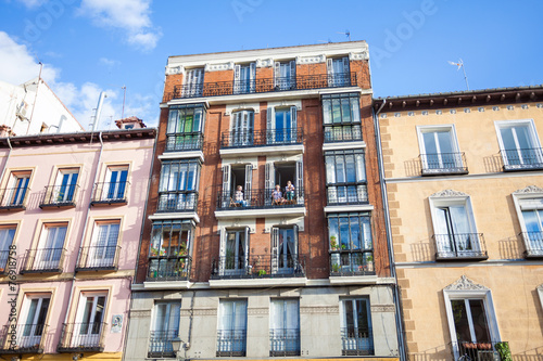 Young girls on balconies of a typical building facade on a stree