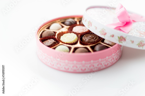 Chocolates in pink box on white background