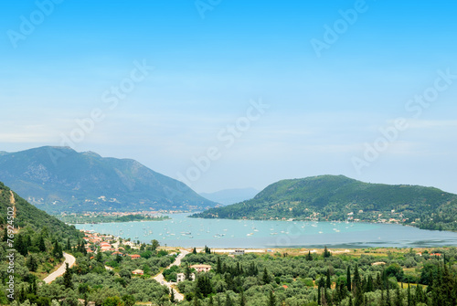 Large sea bay with ships surrounded by green hills photo